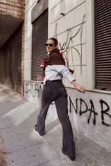 Pantalón de jean recto de tiro medio, con costuras verticales decorativas en el frente y bolsillos laterales. Presenta un diseño de lavado desgastado en tono gris.
