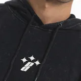Hoodie oversize de color negro con efecto lavado, diseño de mangas superpuestas, bolsillo frontal tipo canguro y cordones ajustables en la capucha. Presenta un pequeño bordado en el centro del pecho.