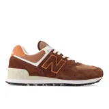 Championes New Balance 574 color marrón, con detalles en naranja y blanco. Confeccionados en gamuza y malla, con logo "N" característico en los laterales y entresuela ENCAP.