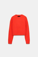 Jersey de punto de cuello redondo y manga larga, con acabado en rib en puños y ruedo.