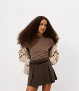 Blusa de manga larga confeccionada en tejido de chenille, con cuello alto y ajuste al cuerpo.