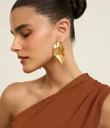 Par de aros maxi con diseño de hoja orgánica y acabado de metal texturizado con baño en tono dorado envejecido.