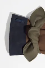 Guantes de diseño patchwork en tonos marrón, verde oliva y azul marino, con detalle de lazo decorativo en la muñeca.