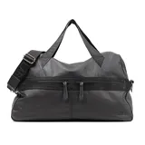 Bolso de mano tipo duffle de cuero negro, con doble asa corta y correa larga regulable con el logo de la marca. Tiene cierre superior y dos bolsillos frontales con cierre.