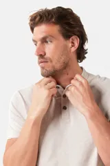 Remera blanca de manga corta con cuello mao y cierre frontal parcial con botones. Presenta detalles en color gris azulado en el cuello y en los bordes de las mangas.