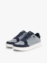 Zapatillas de corte bajo inspiradas en modelos retro de baloncesto, confeccionadas en una mezcla de ante y malla en tonos gris y azul marino. Presentan un diseño de paneles con texturas variadas, cierre de cordones, suela gruesa de goma blanca y detalles distintivos de la marca Tommy Hilfiger.