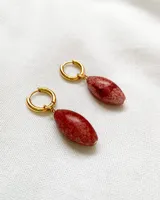 Par de aros colgantes con argolla dorada y dije de piedra veteada color borgoña.