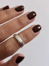Anillo de falange con diseño de superficie irregular y acabado texturizado en plata.