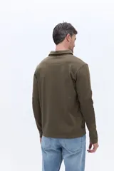 Remera polo de manga larga color bordó, confeccionada en algodón. Presenta cuello clásico con cierre de botones y detalle de logo bordado en el pecho.