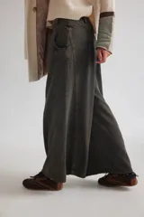 Pantalón de jean con diseño de tiro medio-bajo y piernas anchas. Presenta una pretina ancha con cierre de tres botones metálicos frontales, pinzas decorativas en la cintura y bolsillos delanteros funcionales.