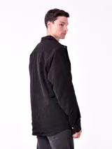 Sobrecamisa de hombre color azul marino, confeccionada en tejido de pana con textura acanalada. Presenta cuello camisero, cierre frontal con botones blancos y dos bolsillos de parche con solapa en el pecho.