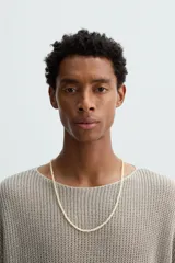 Collar de longitud media compuesto por pequeñas cuentas o abalorios de piedras combinadas en tonos claros y neutros.