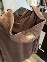 Hoodie de algodón con efecto lavado a la piedra (acid wash) en tono gris oscuro/negro. Presenta un corte relajado (oversize), capucha amplia, bolsillo canguro frontal y el logo "DROPZ" estampado en blanco en el pecho.