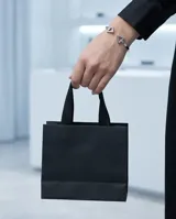 Pulsera rígida abierta de acero plateado, con diseño minimalista que presenta dos triángulos en los extremos.