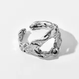 Anillo plateado con diseño irregular y abertura frontal.