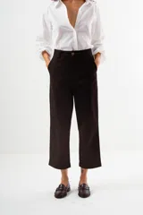 Pantalón de vestir color camel, tiro alto, corte recto y ancho, con puños doblados en el ruedo.