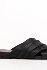 Sandalias chatas de cuero negro con tiras cruzadas y plisadas, y plantilla en tono bordó con punta cuadrada.