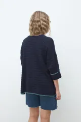 Kimono abierto de tejido de punto azul marino, con mangas tres cuartos y bolsillos frontales con detalles en hilo turquesa.