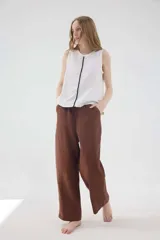 Pantalón de lino de silueta relajada, tiro medio-alto, cintura elastizada con jareta y cuerda, bolsillos laterales y traseros.
