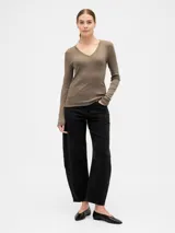 Remera de manga larga con escote en V, confeccionada en tejido de algodón suave y elástico, con un corte ajustado al cuerpo.