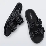 Sandalias de plataforma plana Melissa Possession Slip color negro, de diseño moderno y práctico, con tiras anchas texturizadas y hebillas decorativas, elaboradas en material sintético flexible tipo gelatina.