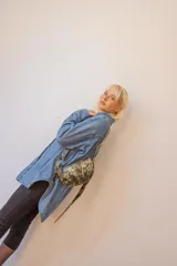 Bandolera de cuero color rojo con detalles en negro, con correa regulable y cierre superior con cremallera.