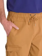 Pantalón cargo color tostado, con bolsillos laterales tipo cargo, cintura elástica y puños elásticos en los tobillos.