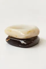 Pack de tres brazaletes rígidos de resina con acabado brillante. Incluye un brazalete carey oscuro (marrón/verde), uno rojo oscuro y uno blanco con vetas marrones.