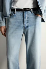 Jeans de corte regular cropped confeccionados en denim ligero de algodón. Presentan un diseño de cinco bolsillos con efecto lavado, tiro medio y cierre frontal con botones.