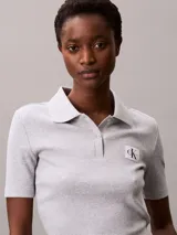 Chomba de Calvin Klein Jeans confeccionada en tejido de algodón con elastano, de corte regular y textura acanalada. Presenta cuello tipo polo con cartera de dos botones y una insignia distintiva de la marca aplicada en el pecho.
