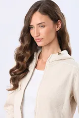 Campera de felpa con cierre frontal, cuello alto y capucha integrada. Presenta un diseño de textura jaspeada en tono beige claro.