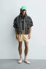 Cazadora de corte relajado confeccionada en piel con acabado de serraje. Presenta cuello solapa, cierre frontal con cremallera oculta bajo solapa con botones a presión, bolsillo con cremallera en el pecho y bolsillos de plastrón con solapa en la cadera. Incluye efecto vintage en las costuras y puños con botón.