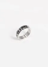 Anillo de acero quirúrgico plateado con aro giratorio con diseño de flores negras.