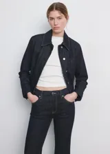 Jeans de denim azul oscuro de tiro medio y corte acampanado, con costuras contrastantes y bolsillos clásicos.
