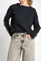 Sweater de algodón negro con calce oversize, cuello redondo y mangas largas con detalle de línea blanca lateral.