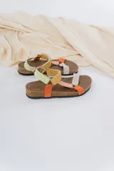 Sandalias con base anatómica de corcho y suela antideslizante. Presentan tiras de cuero suave combinadas en tonos pastel y tierra, y cierre adherente regulable.