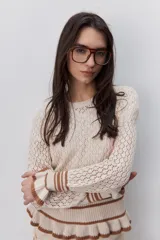 Sweater calado de algodón color celeste, con cuello redondo, mangas largas y diseño cómodo. Presenta puños, cintura y terminaciones acanaladas con rayas en contraste de color marrón.