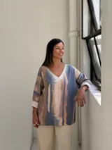 Sweater de tejido de punto con diseño abstracto en tonos azul, beige y rosado, de corte holgado y mangas largas con puños vueltos.