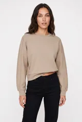 Buzo de cuello redondo color beige melange, confeccionado en tejido suave de manga larga con hombros caídos y puños elásticos.