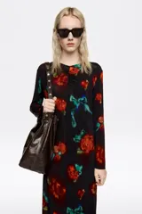 Vestido midi de corte recto con estampado abstracto en tonos terracota y negro. Presenta escote redondo con detalle de fruncido central y mangas largas.