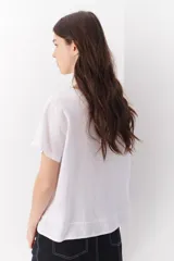 Blusa de lino color verde lima, con escote en V, mangas cortas y detalle de pliegue frontal.