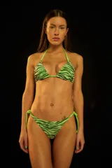 Conjunto de bikini verde con estampado animal print. El corpiño es de triángulo con tirantes ajustables y la bombacha es vedetina con tiras ajustables en los laterales.