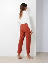 Pantalón de gabardina elastizada color fucsia, de corte recto y pretina ancha pespunteada. Tiene bolsillos simulados.