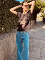 Remera negra de algodón con spandex, cuello redondo y estampado de rayo en gamuza color marrón.