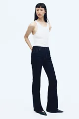 Jean de tiro alto con corte acampanado desde la rodilla, confeccionado en denim oscuro con cinco bolsillos y cierre frontal con botón.