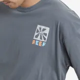 Remera de corte oversize color azul, con cuello redondo y manga corta. Presenta un pequeño estampado gráfico en el pecho con el logo de la marca Reef.