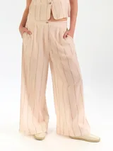 Pantalón de lino a rayas, con diseño de pierna ancha, pretina con elástico y bolsillos laterales.