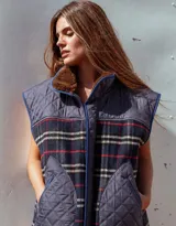 Chaleco acolchado combinado en tela matelasse azul y tweed a cuadros, con cuello alto forrado en corderito sintético marrón, bolsillos frontales amplios con cierre y cierre frontal.