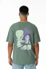 Remera verde salvia de corte relaxed con estampa en la espalda de un alien, un skater y criaturas conspirando.