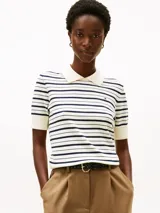 Sweater tipo chomba Tommy Hilfiger de manga corta, confeccionado en algodón orgánico. Presenta un diseño de rayas horizontales azul marino sobre fondo blanco, con cuello y puños acanalados en color blanco y el logo bordado en el pecho.